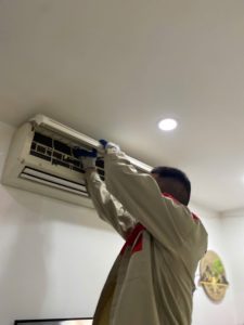 Hình ảnh thợ đang kiểm tra điều hòa kêu lạch cạch ban đêm